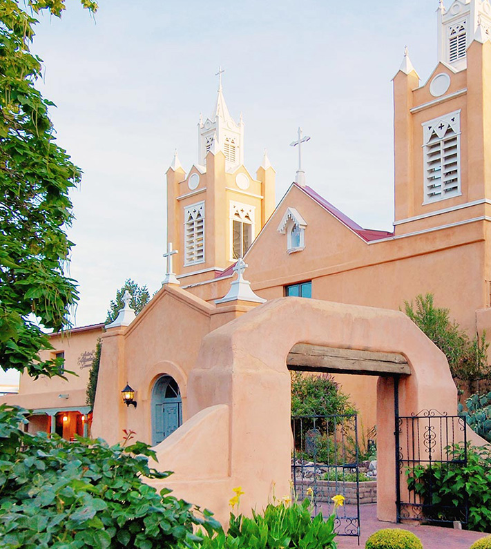Daytime image of the San Felipe Church in a clay bulding style New Mexico is known for.