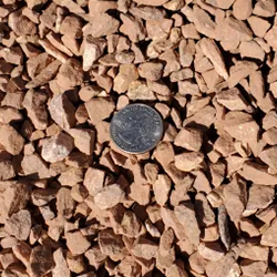 Blush 7/16 inch gravel, showcasing an enchanting medley of stones in delicate blush tones, elegantly complemented by a quarter for size reference. Available exclusively at Albuquerque Landscape Supply, this exceptional gravel adds a touch of sophistication to outdoor spaces. Whether used for walkways, garden accents, or artistic arrangements, it brings a subtle warmth and serene ambiance to any landscape design.