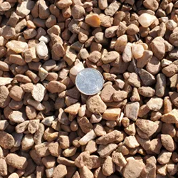 Mountainair Brown 7/16 inch gravel, featuring a finely sized blend of stones in rich brown hues, accompanied by a quarter for size reference. Available at Albuquerque Landscape Supply, this high-quality gravel adds elegance and versatility to outdoor projects. Use it for pathways, patio areas, or as a decorative ground cover to create a polished and inviting outdoor space.