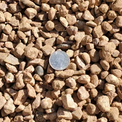 Santa Fe Brown 7/16 inch gravel, featuring a charming blend of stones in warm brown tones, accompanied by a quarter for size reference. Available at Albuquerque Landscape Supply, this high-quality gravel adds a touch of elegance to outdoor spaces. Use it for pathways, garden borders, or as a decorative ground cover to create a welcoming and inviting atmosphere in your landscape design.